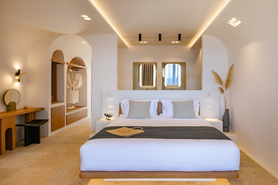 santo mine santorini volcanic rock hotel interior suite bed neutral tones